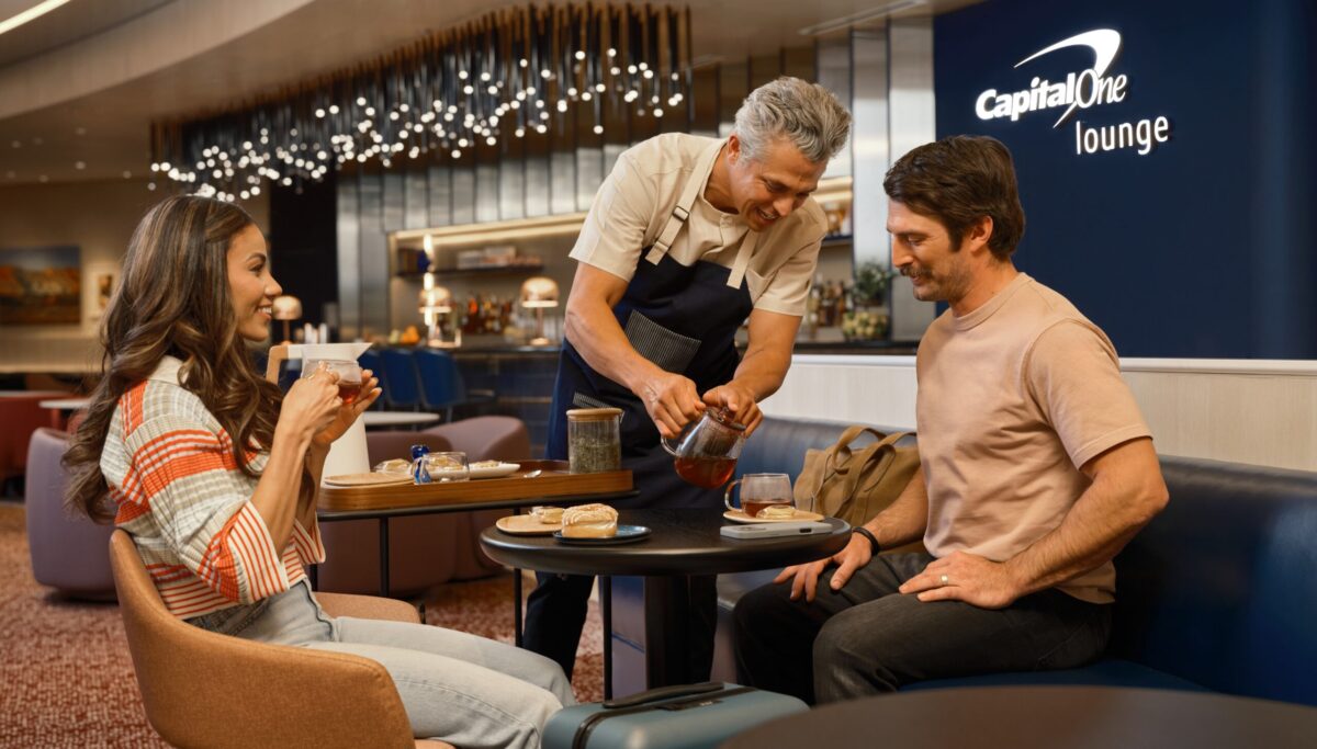 A Capital One lounge employee pours tea for a patron.